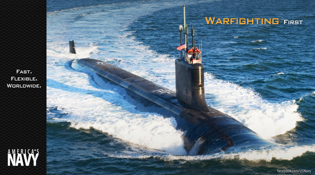 Marine-U-Boot mit "Warfighting First" auf der Seite, einer Fahne oben und einigen Menschen darauf, umgeben von Ozean.