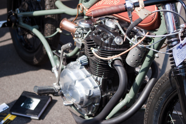 Mehrere Motorräder auf der Straße mit einem Buch auf einem der Sitze geparkt.