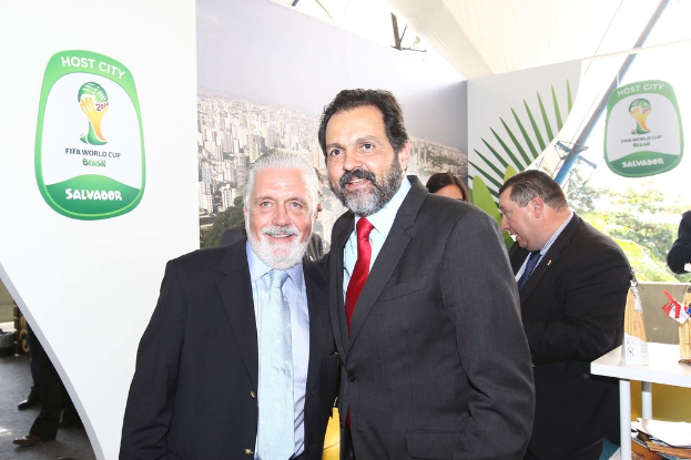 Eine Gruppe von Menschen, die mit einigen lächelnden Gesichtern stehen, mit einem FIFA-Weltmeisterschaftsposter im Hintergrund.