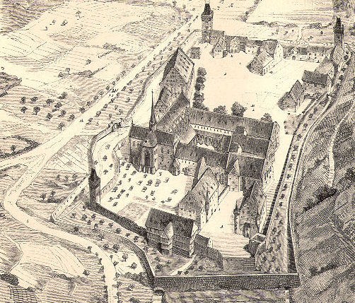 Schwarzer und weißer Luftaufnahme einer Stadt mit einer zentralen Kirche, umgeben von Gebäuden, Bäumen und Straßen, mit Text am unteren Rand.