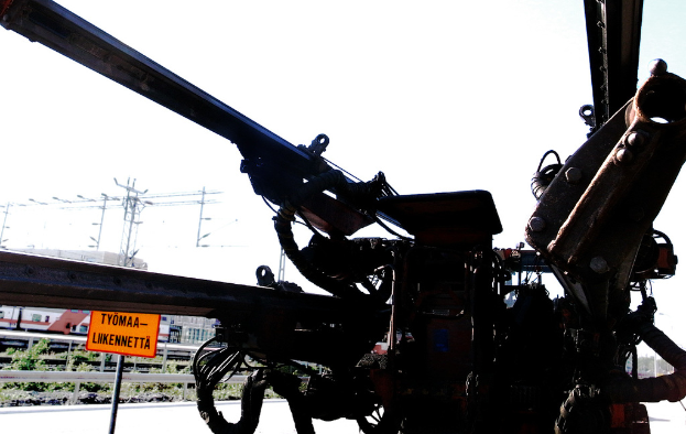 Eine Maschine mit elektrischen Polen, Kabeln, Barrieren, Pflanzen und Himmel im Hintergrund.