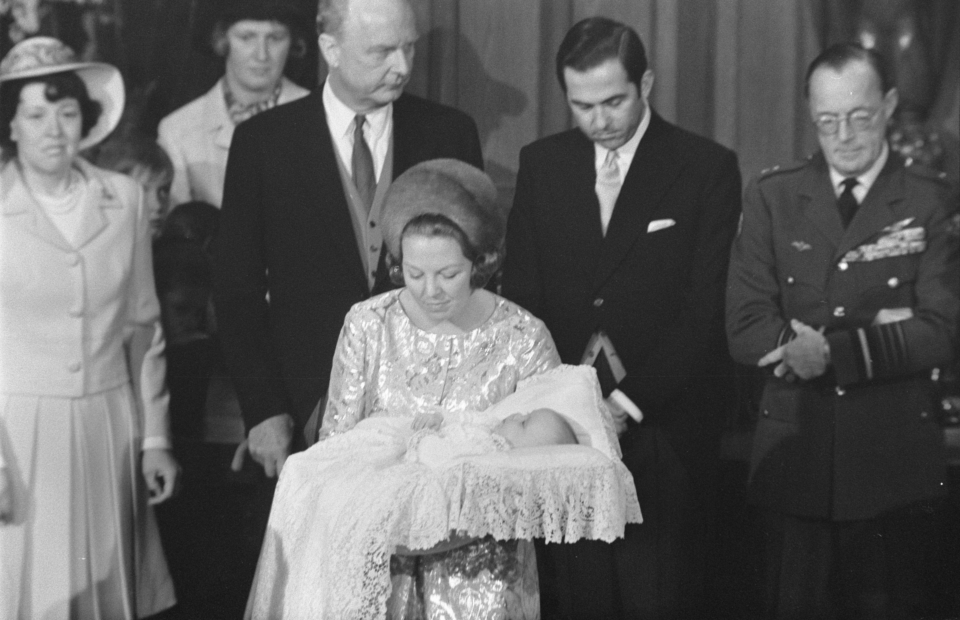 Königin Elizabeth II. hält das Neugeborene Prinz Philip, mit Prinz Philip, Herzog von Edinburgh, der neben ihnen in einem Anzug und Krawatte steht, vor einem Vorhanghintergrund.