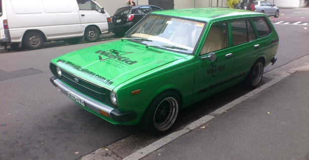 Eine Person steht in der Nähe einer Straße mit Fahrzeugen.