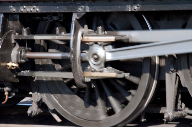 Ein Detailbild eines Zugrades auf einer Eisenbahnschiene.