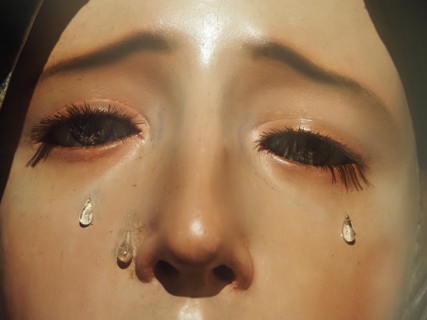 Eine Frau mit Tränen im Gesicht, ihr Gesichtsausdruck zeigt Traurigkeit und Verzweiflung.