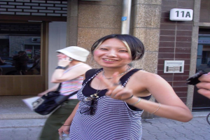 Frauen auf einer Straße mit einer Wand, einer Pipeline und Fenstern im Hintergrund.