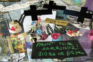 Kreuze, Papiere und Schlüsselanhänger auf einem Glastisch verstreut.