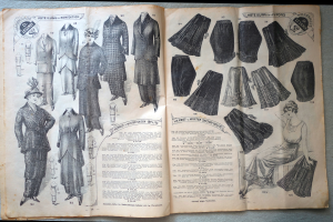 Ein aufgeschlagenes Buch mit Bildern von Frauenkleidung und Text, das die Mode einer bestimmten Zeit zeigt.