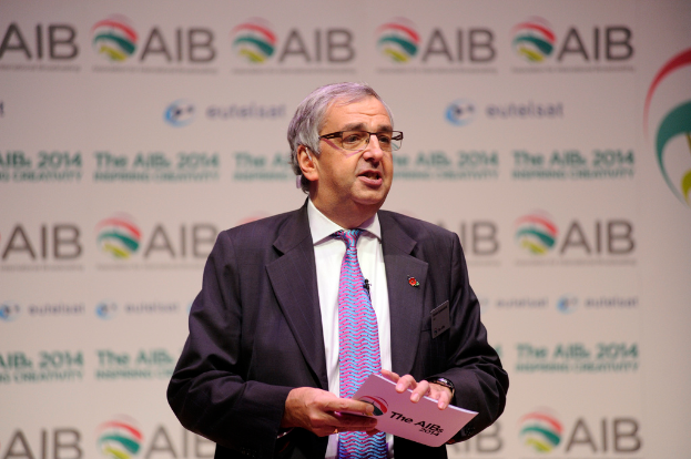 Eine Person hält ein Buch vor einem Banner.