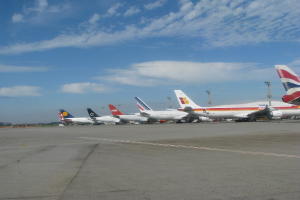 Eine Start- und Landebahn mit einigen Flugzeugen, Polen, Kabeln und einer bewölkten Himmel.
