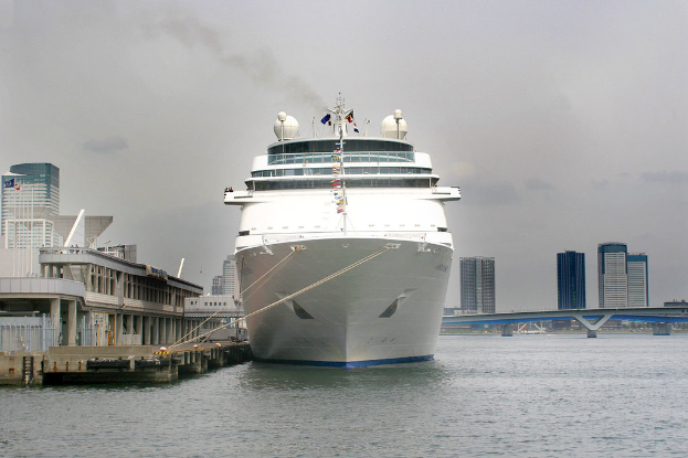 Ein Schiff schwimmt auf dem Wasser neben einer Brücke und zahlreichen Geb√§uden.