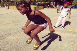 Ein wenig besiedeltes Gebiet mit einem Zaun, Bäumen und Autos im Hintergrund.