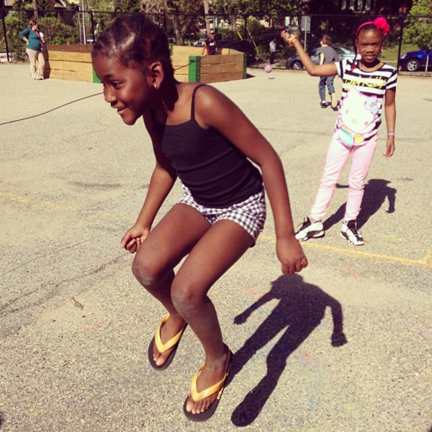 Ein wenig besiedeltes Gebiet mit einem Zaun, Bäumen und Autos im Hintergrund.