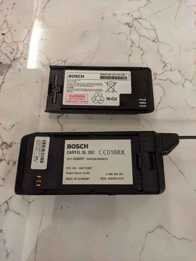 Zwei schwarze Bosch-Batterien mit dem Bosch-Logo und dem Wort "Bosch" in fetter Schrift auf einem weißen Marmortresen.