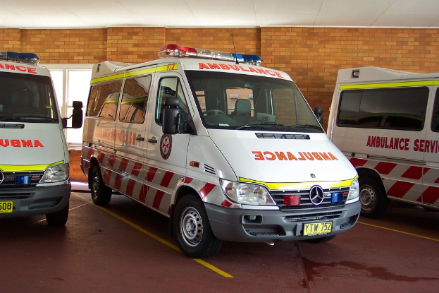 Ein Notarztwagen in Weiß ist vor einer Backsteinwand geparkt.