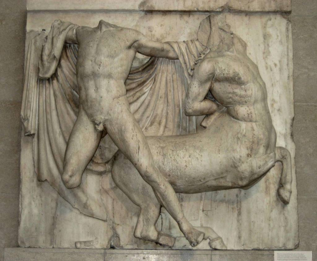 Skulpturen an einer Wand montiert mit Text, der unten im Bild angezeigt wird.