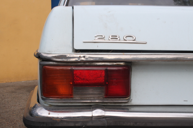 Ein Auto fährt auf einer Straße vor einer Wand.