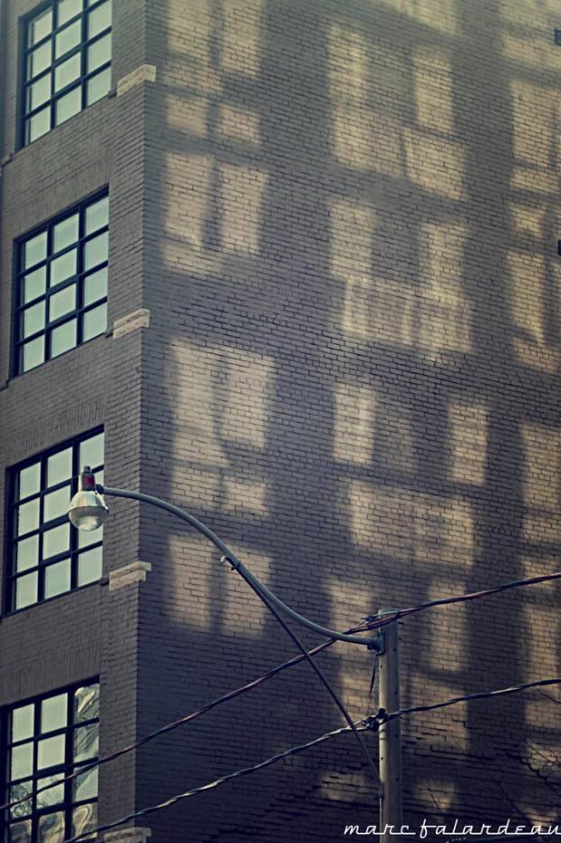 Ein Gebäude mit Glasfenstern auf der linken Seite und einer Lampe an einem Pfahl unten.
