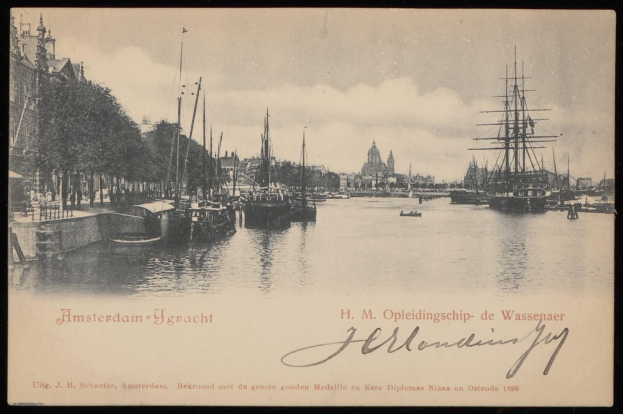 Ein altes Schwarz-Weiß-Foto von Booten, die in einem Hafen mit Gebäuden, Bäumen und Himmel im Hintergrund liegen, mit Text unten, der "Amsterdam-ygracht - h m opleidingship de wassenaar" lautet.
