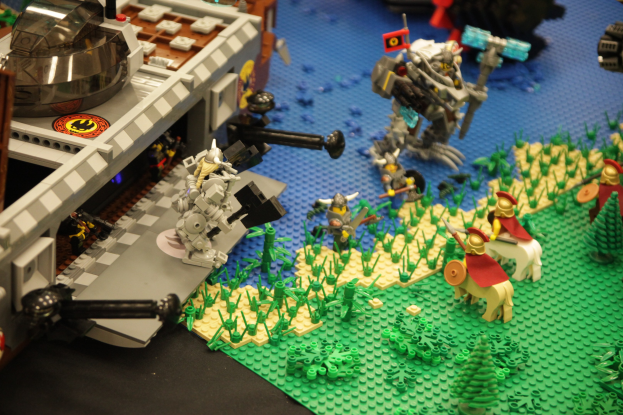 Lego-Schlossmodell mit verstreuten Lego-Teilen, darunter Spielzeuge, Pflanzen und andere Gegenstände.