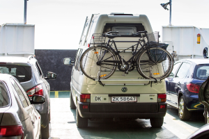 Verschiedene Fahrzeuge, darunter Autos und Fahrräder in verschiedenen Farben, sind in der Mitte des Bildes positioniert.