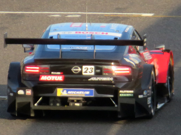 Audi R8 LMS GT3 Rennwagen auf einer Rennstrecke, positioniert für eine Kurve mit sichtbaren Rädern und Sportwagenkarosserie.