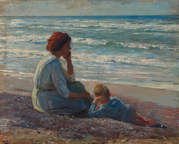 Eine Mutter in einem hellen Kleid und ein junger Junge sitzen an einem goldenen Strand und sehen dabei zu, wie die Sonne über dem Ozean untergeht.