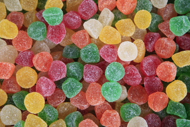 Verschiedene Zuckerbonbons in verschiedenen Farben sind in einem Behälter angeordnet.