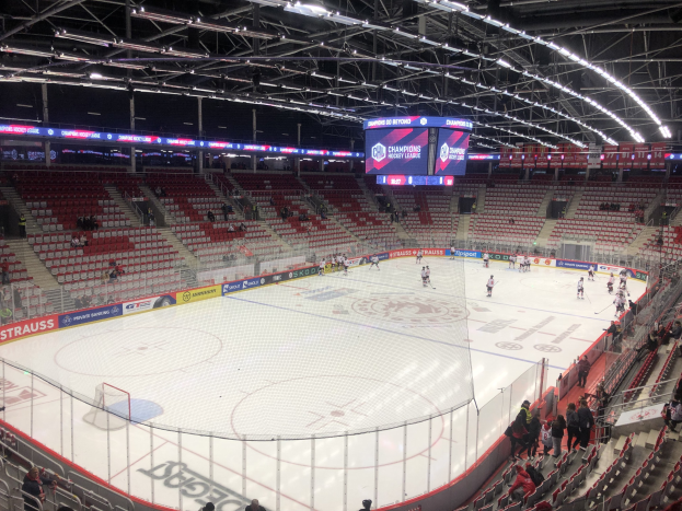 Hockey-Spiel in einer großen Arena zwischen den St. Louis Blues und Detroit Red Wings, mit Zuschauern auf den Sitzen und Stehplätzen in der Nähe der Eisfläche.