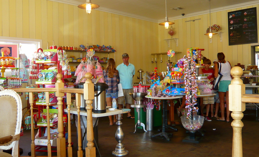 Eine Gruppe von Menschen vor einem Geschäft mit Bonbons, Süßigkeiten und Backwaren.