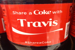 Eine Coca-Cola-Flasche mit der Aufschrift "Teile eine Coke mit TRAVIS".