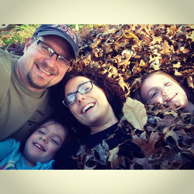 Eine Gruppe strahlender Menschen mit Pflanzen im Hintergrund.