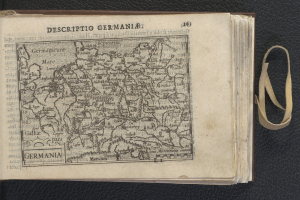 Ein offenes Buch mit einer Deutschlandkarte und begleitendem Text, auf einer schwarzen Oberfläche plaziert.