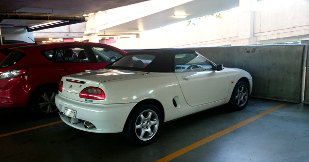 Autos in einem Keller mit einem Rohr auf dem Dach und einem weiteren Gebäude oben rechts.