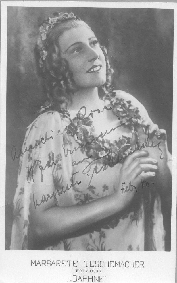 Schwarz-weiß-Foto einer Frau in einem Kleid mit einer 1940er-Jahre-Frisur, die warm lächelt mit hellen Augen und leicht geöffneten Lippen.