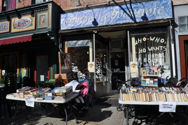 Eine Stadtansicht mit Gebäuden, Bäumen, Pfählen, Straßen, Fahrzeugen und einem Himmel.