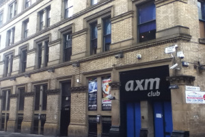 Ein Schaufenster mit Plakaten und ein Geb├Ąude im Vordergrund.