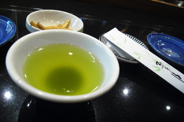 Ein schwarzes Tablett mit einem Teller, einer Schüssel und einem nicht identifizierbaren Objekt.