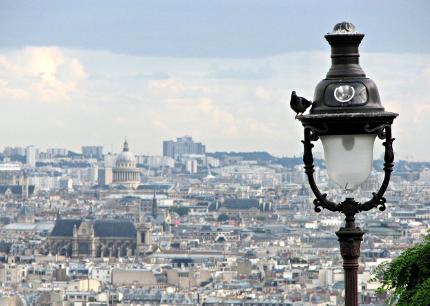 Eine Vogelperspektive einer Stadtlandschaft mit Gebäuden und einem schwarzen und weißen Laternenmast im Vordergrund.