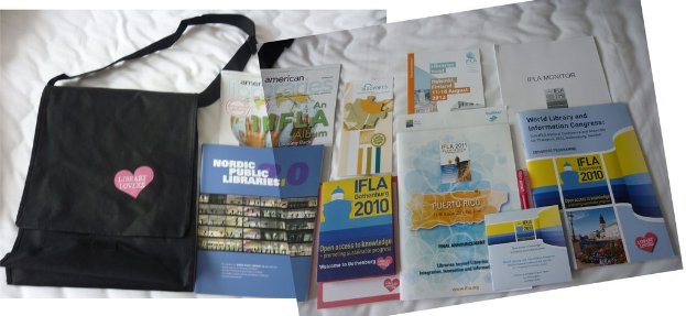 Eine Tasche mit "Bibliothek-Liebhaber" drauf und einige Bücher auf einem Bett.