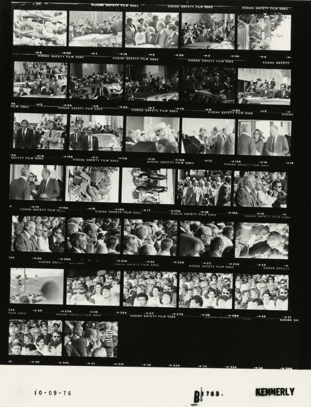 Schwarzes und weißes Foto einer vielseitigen Menschenmenge, die fröhlich in eine Fernsehbildschirm schaut, mit Text unten.